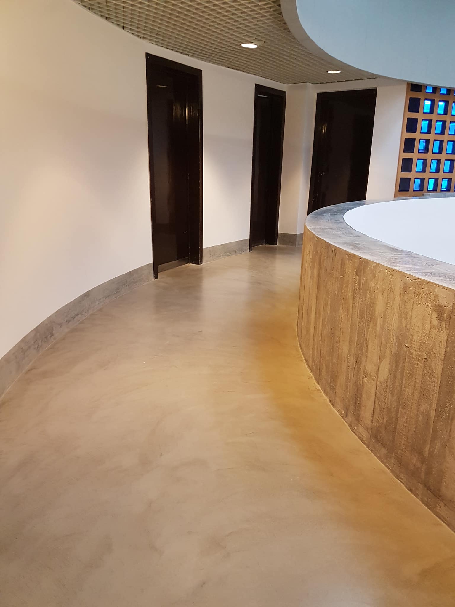Pavimento in microcemento curvo per spazio commerciale